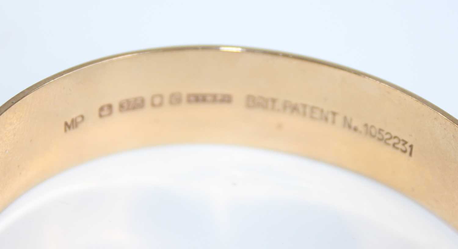 A 9ct gold hinged bangle, having bright cut engraved decoration, with gilt metal safety chain, - Image 3 of 4
