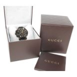 A steel and yellow Gucci G chrono quartz watch, having round black baton dial and sub dials at 6 and