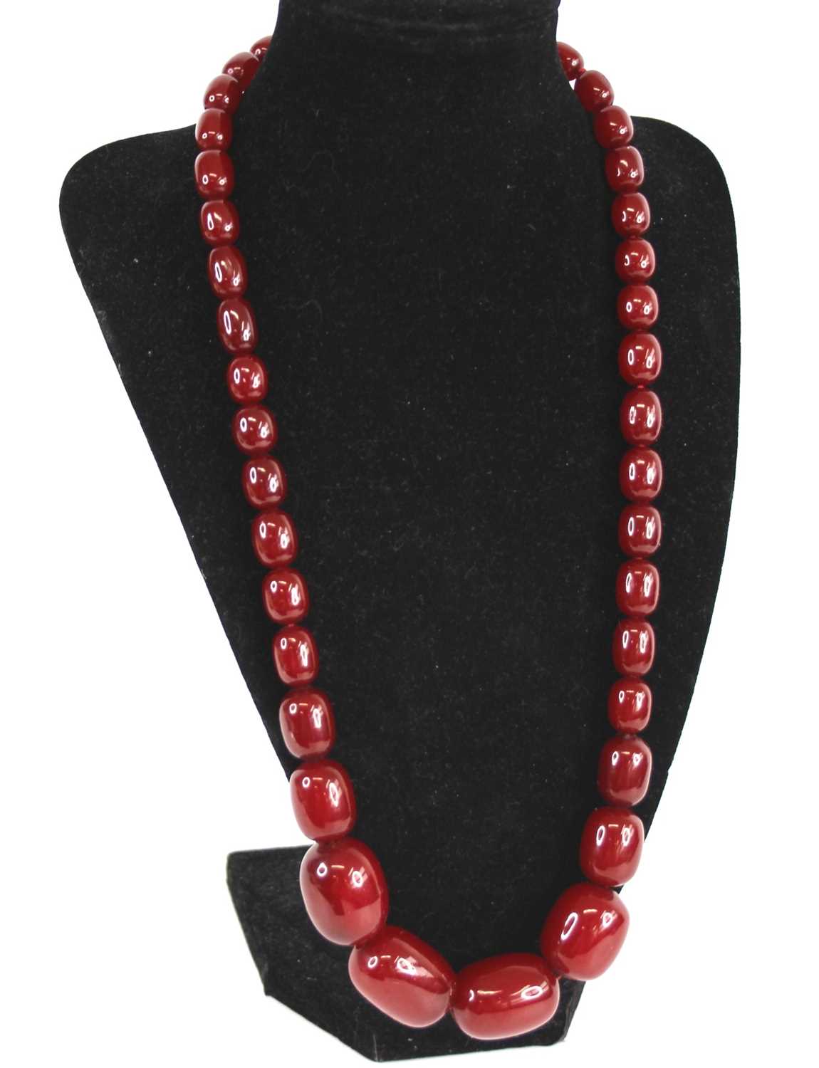 A cherry amber single string necklace, arranged as 40 graduated barrel beads, the largest w.25mm,