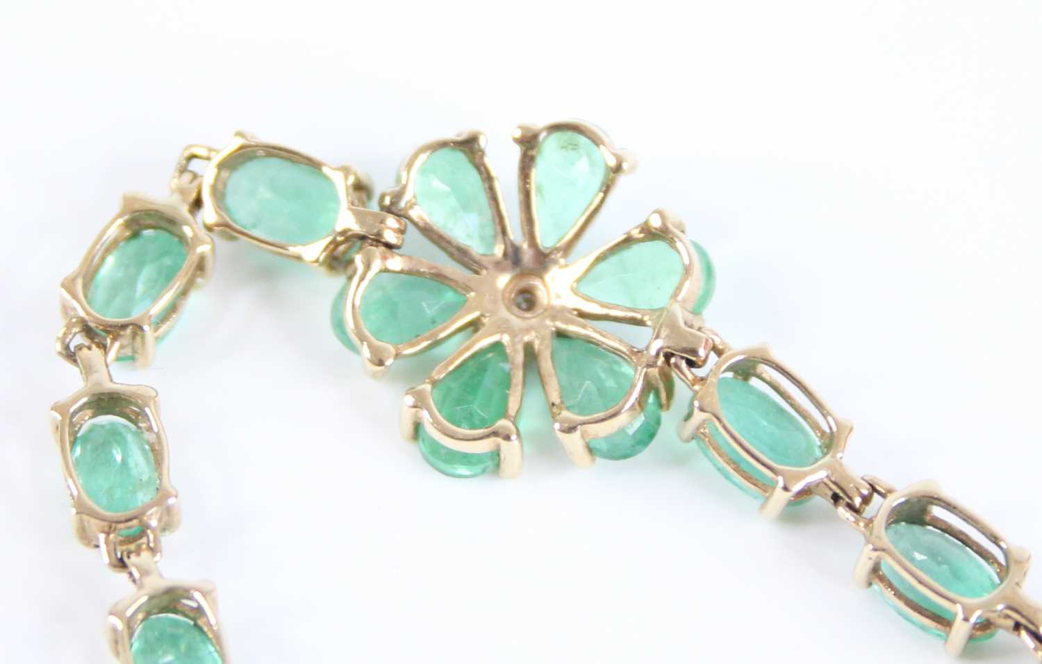 A 9ct yellow gold emerald multi-stone bracelet, comprising a centre flower motif with six pear cut - Image 6 of 6