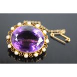 A yellow metal, amethyst and pearl oval cluster brooch, featuring a centre oval amethyst bezel set