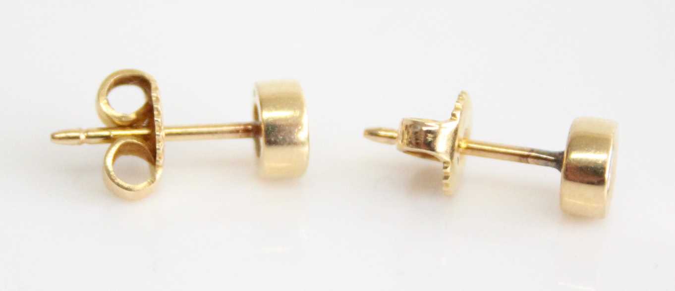 A pair of yellow metal diamond stud earrings, each featuring a round brilliant cut diamond in a - Image 2 of 4