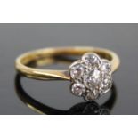 An 18ct gold and platinum diamond flower head cluster ring, arranged as seven pavé set old round