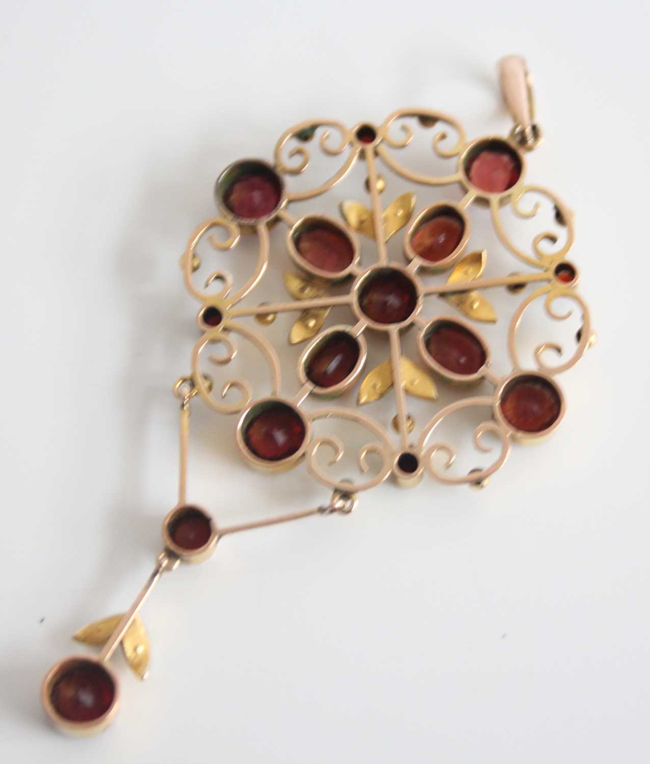 A yellow metal Edwardian openwork garnet and seed pearl pendant, featuring ten round and four oval - Image 2 of 3