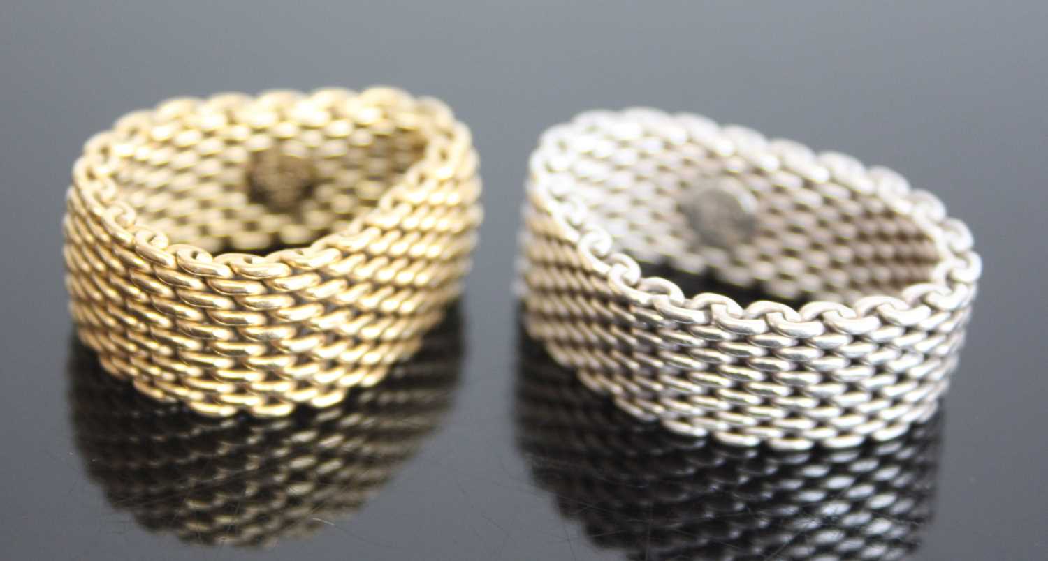 Two marked Tiffany & Co rings. One yellow metal 10mm wide mesh link ring, finger size T approx.