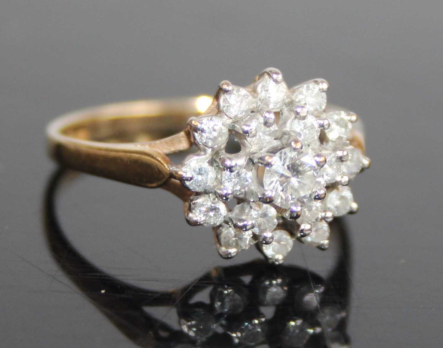 A 9ct yellow and white gold diamond circular cluster ring, comprising 19 round brilliant cut