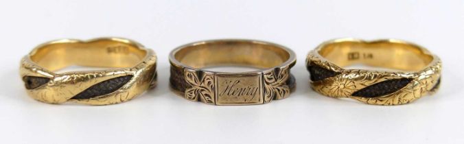 Three yellow metal and woven hair mourning rings, comprising two twisted bands with engraved