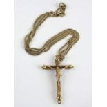 A yellow metal ornate crucifix attached to a curb link long guard chain, with swivel clasp, crucifix