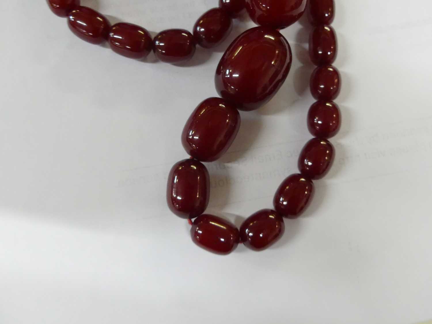 A cherry amber single string necklace, arranged as 40 graduated barrel beads, the largest w.25mm, - Image 11 of 14