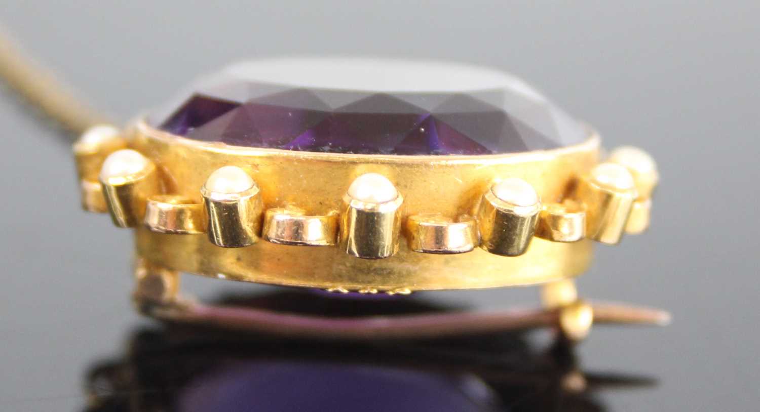 A yellow metal, amethyst and pearl oval cluster brooch, featuring a centre oval amethyst bezel set - Image 3 of 4