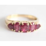 A 14ct yellow gold ruby half hoop eternity ring with 3 graduated oval and 2 trilliant cut rubies