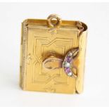 A late 19th century pendant locket in the form of a book, having concertina action to allow four