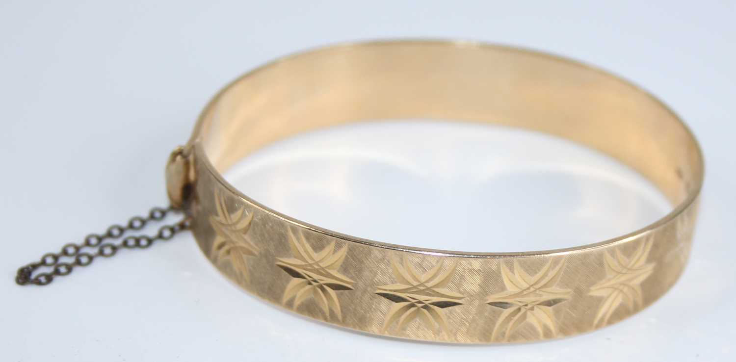 A 9ct gold hinged bangle, having bright cut engraved decoration, with gilt metal safety chain, - Image 2 of 4