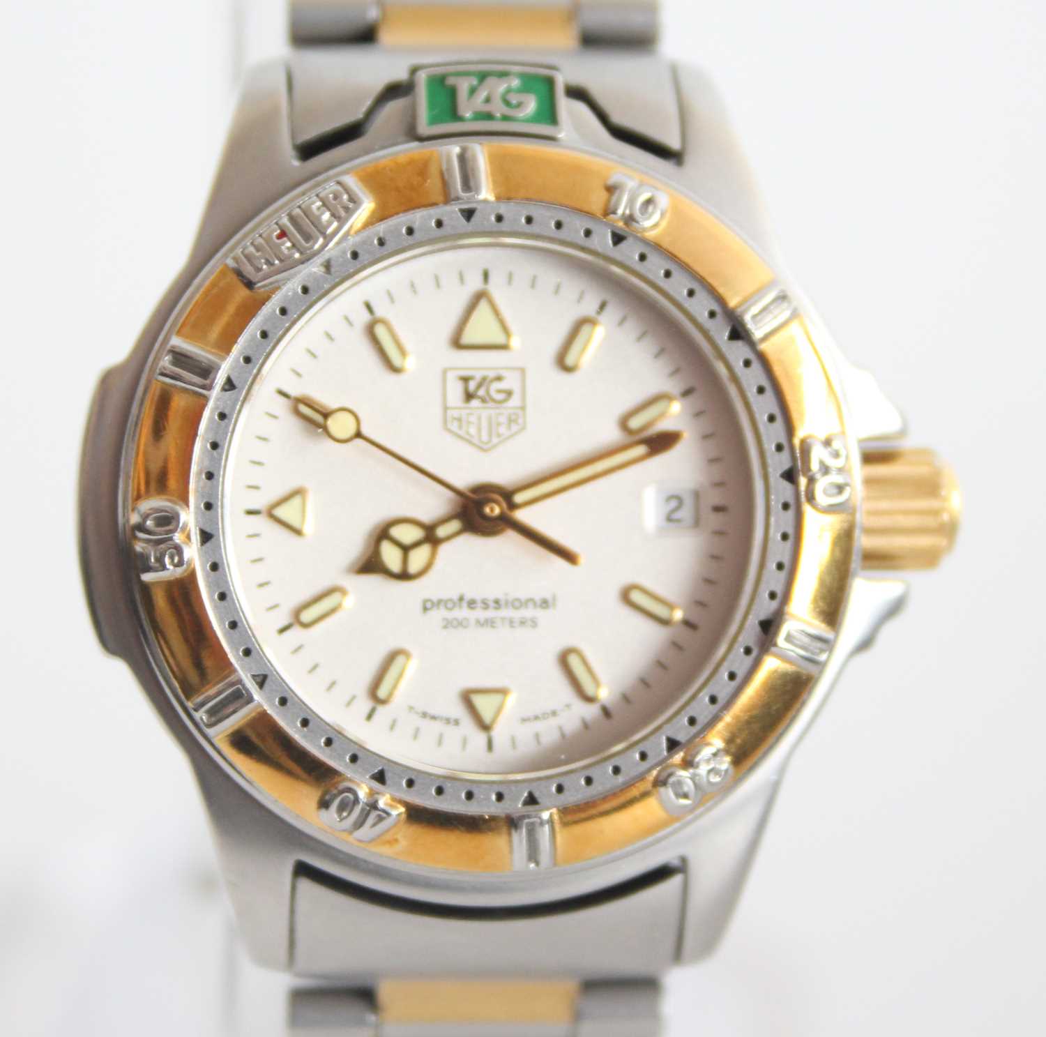 A ladies bi-metal Tag Heuer professional quartz watch with round cream baton dial and date at 3,