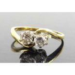 An 18ct yellow and white gold, diamond two-stone crossover style ring, having two round brilliant