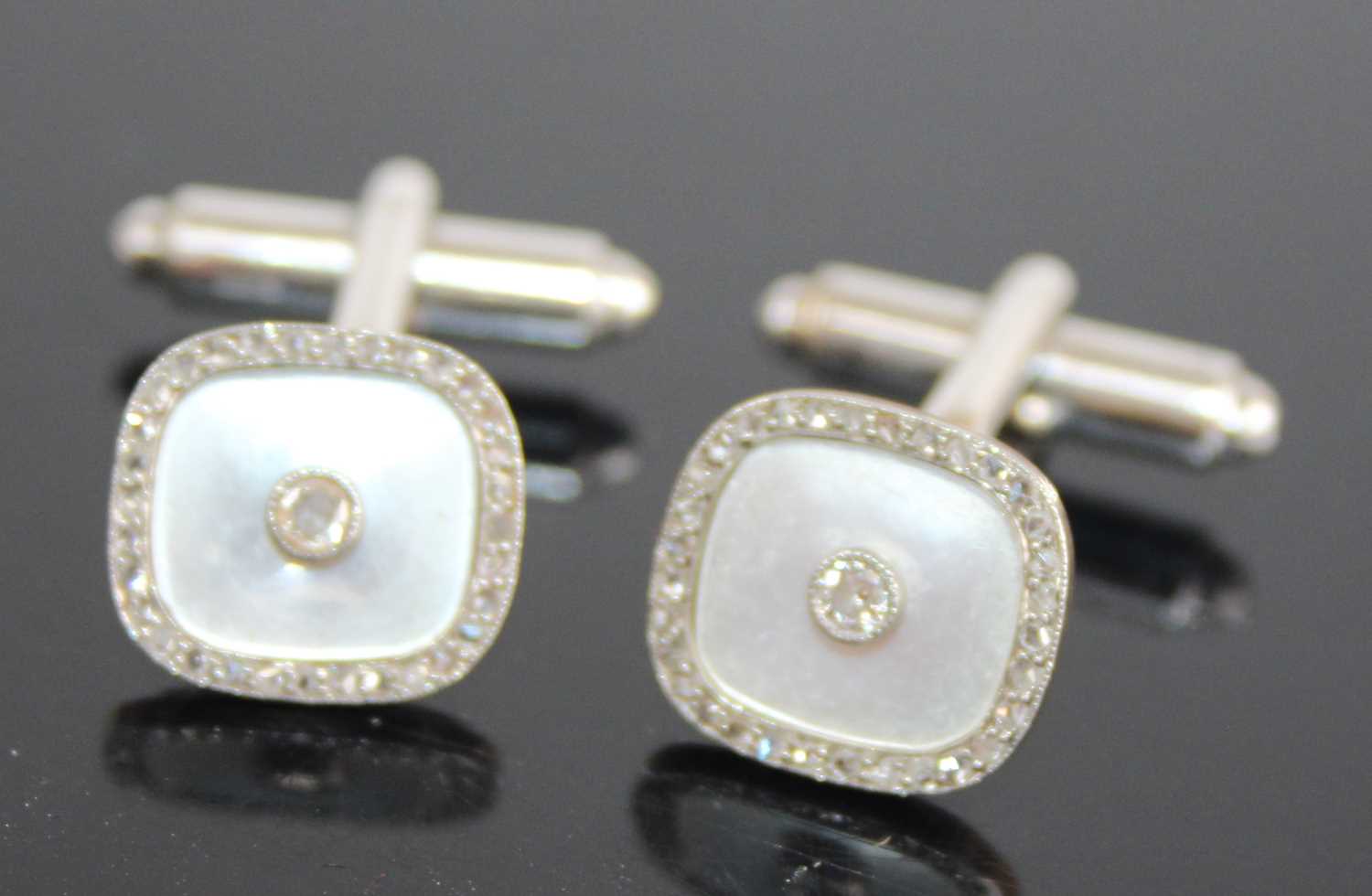 A pair of 9ct yellow and white gold diamond set cufflinks, the shaped square mother of pearl inset