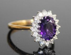 A contemporary 18ct gold, amethyst and diamond flower head cluster ring, the claw set oval cut