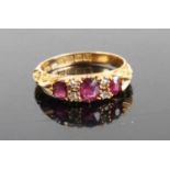 An Edwardian ruby & diamond half hoop ring, arranged as three graduated oval cut rubies, the largest