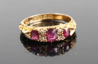 An Edwardian ruby & diamond half hoop ring, arranged as three graduated oval cut rubies, the largest