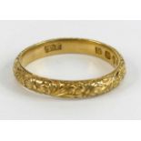 An 18ct yellow gold 3mm engraved band ring, with raised floral detail, size L, gross weight 3g,