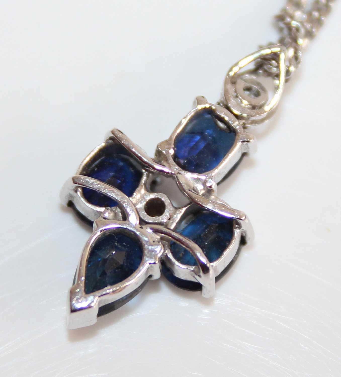 A white metal, sapphire and diamond point set pendant, arranged as two oval and two pear cut - Image 4 of 5