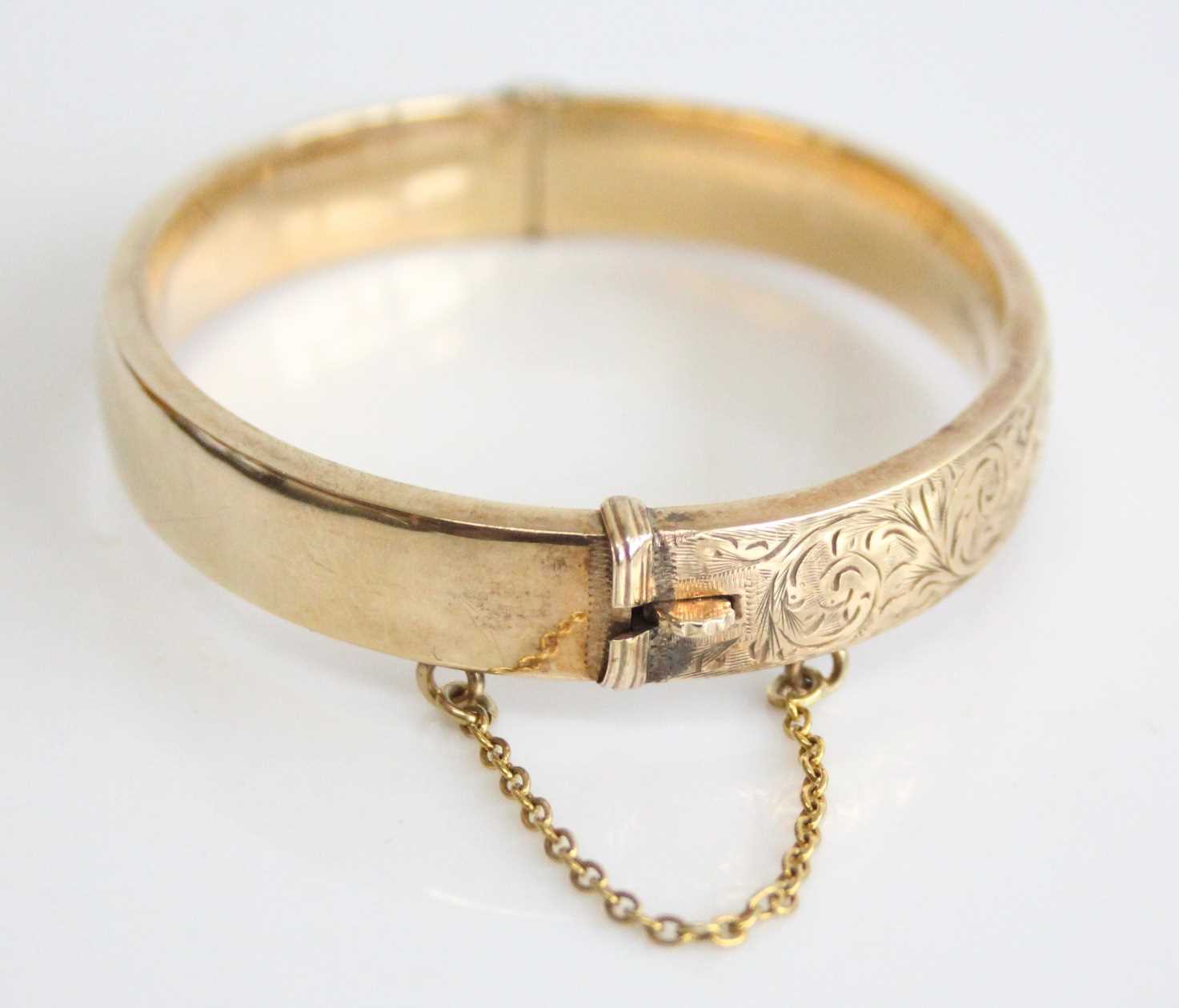 A 9ct yellow gold oval hinged hollow bangle, half engraved with scrollwork detail, with a box - Image 4 of 6