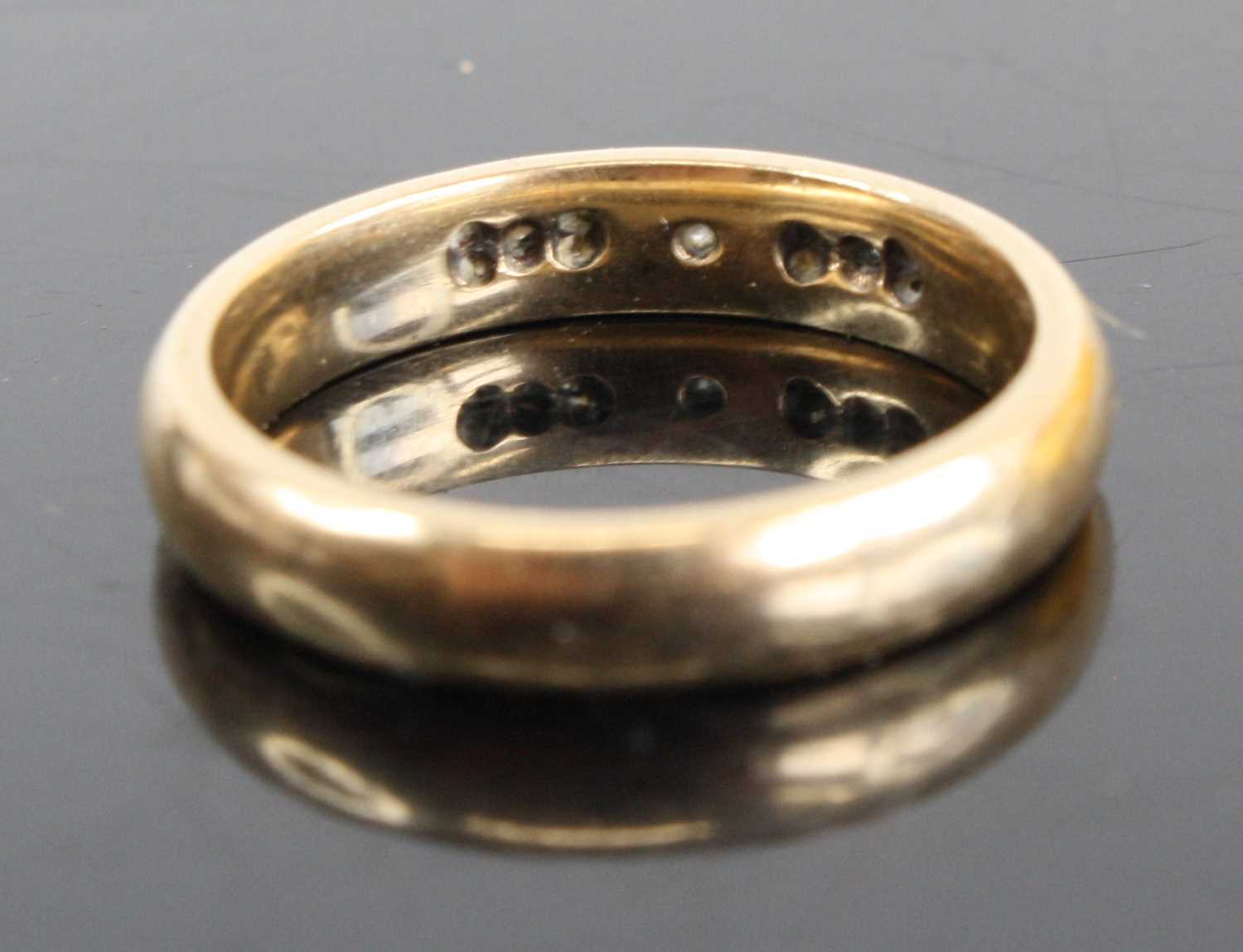 A 9ct gold diamond set band ring arranged as a centre round cut weighing approx 0.05ct, flanked to - Image 2 of 4