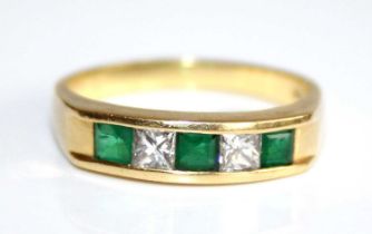 An 18ct gold, emerald and diamond set half hoop ring, arranged as two Princess cut diamonds