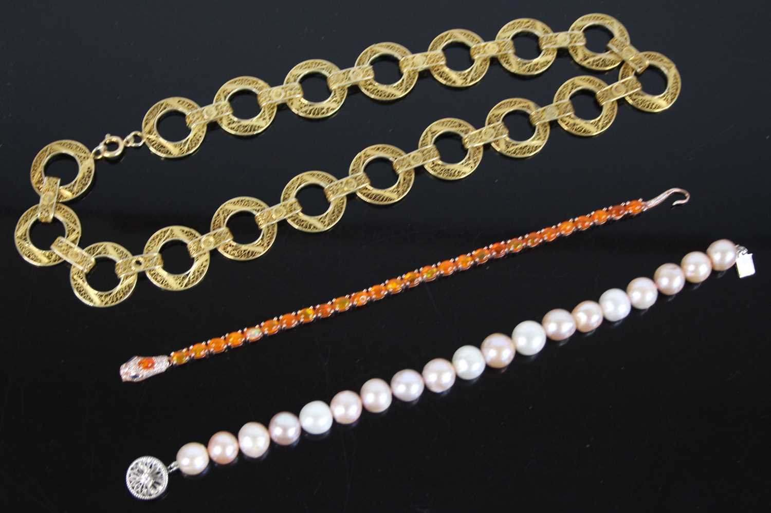 Two bracelets and a necklace, being a gilt metal snake bracelet with 28 oval orange paste stones