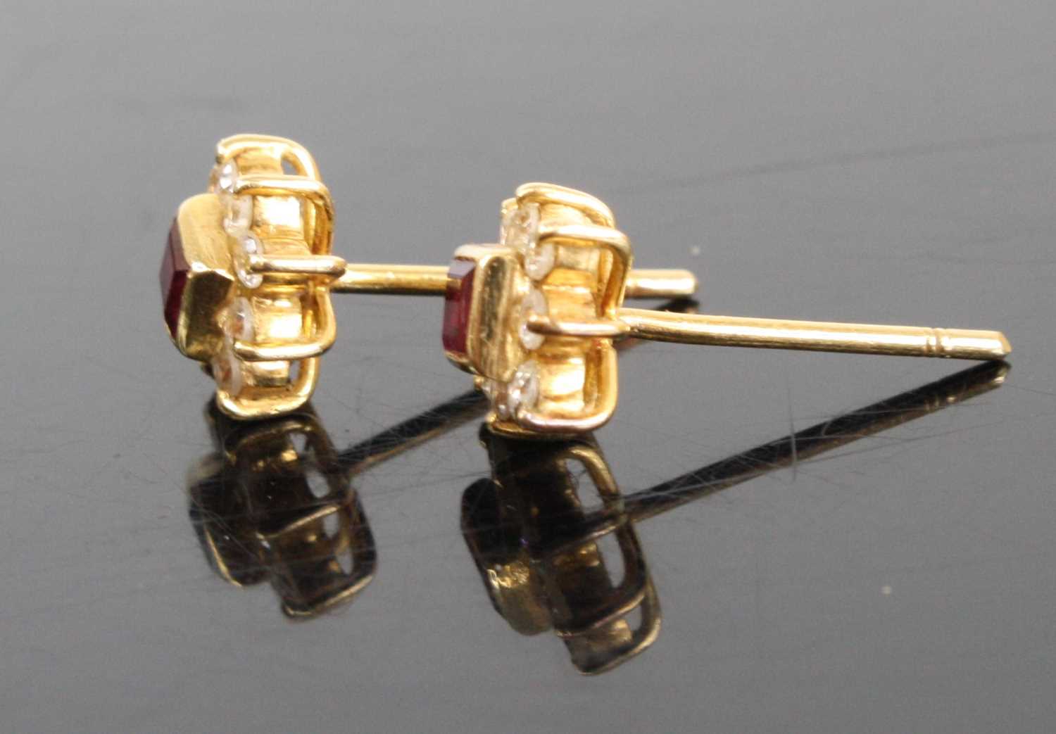 A pair of yellow metal ruby and white stone set flowerhead ear studs, the square cut rubies - Image 2 of 2