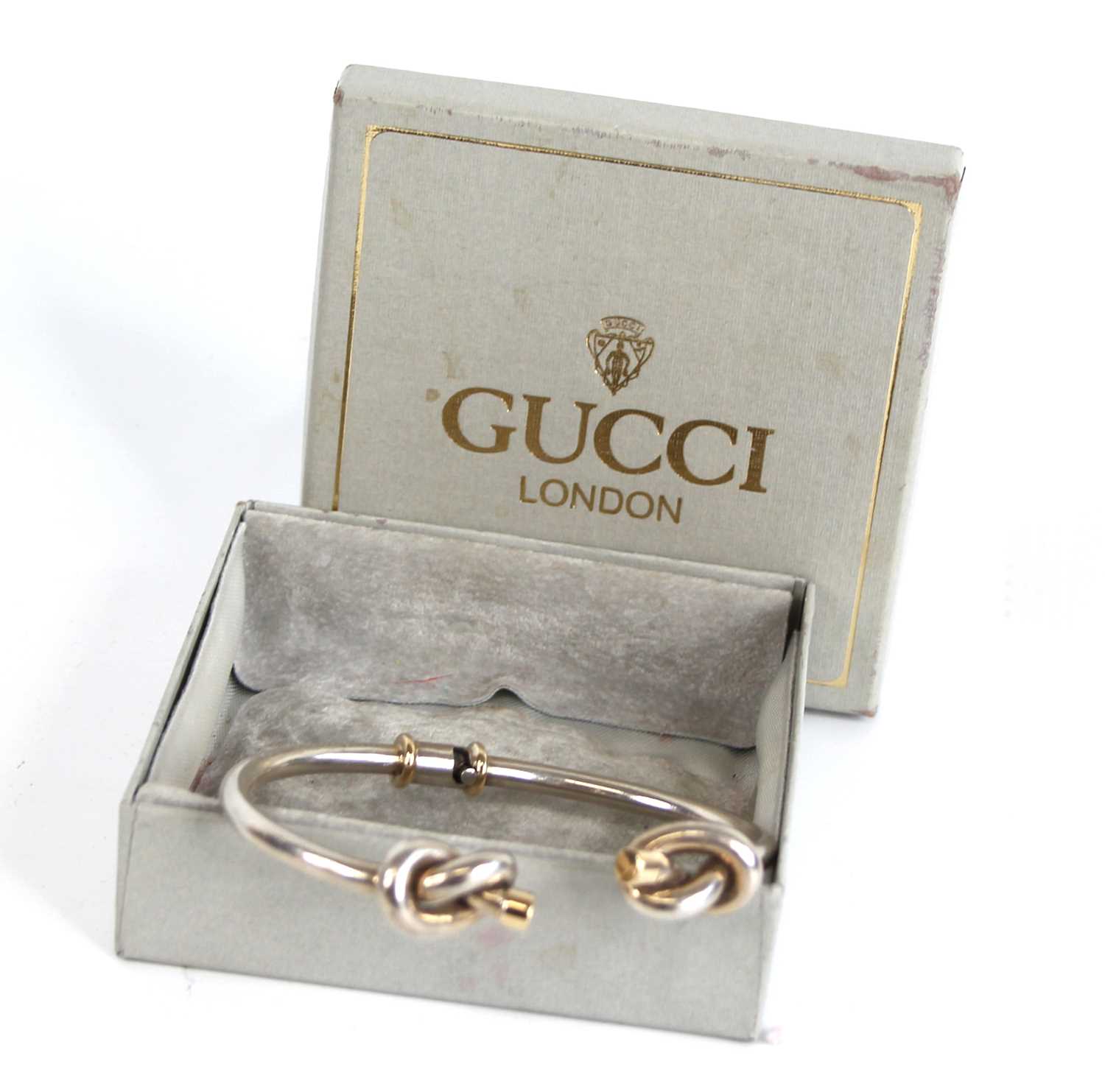 A Gucci silver and 18ct gold tipped bangle, having knotted ends and twist action, 34g, 7cm, boxed - Image 5 of 5