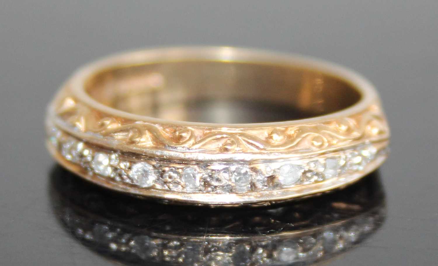 A 9ct gold diamond half eternity ring, arranged as nine small round cuts in a carved setting,