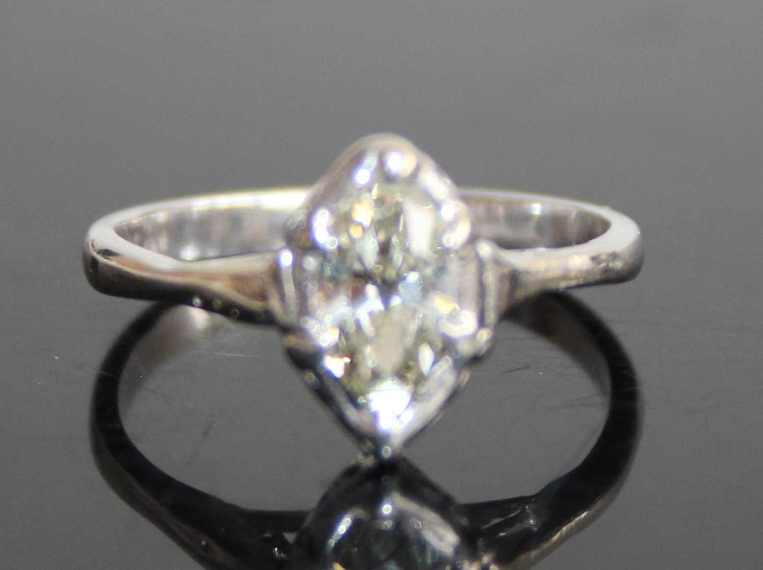A platinum and diamond single stone ring, the bezel set marquise cut tinted diamond measuring approx