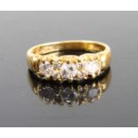 An 18ct gold diamond half hoop ring, arranged as three claw set round brilliants in a line setting