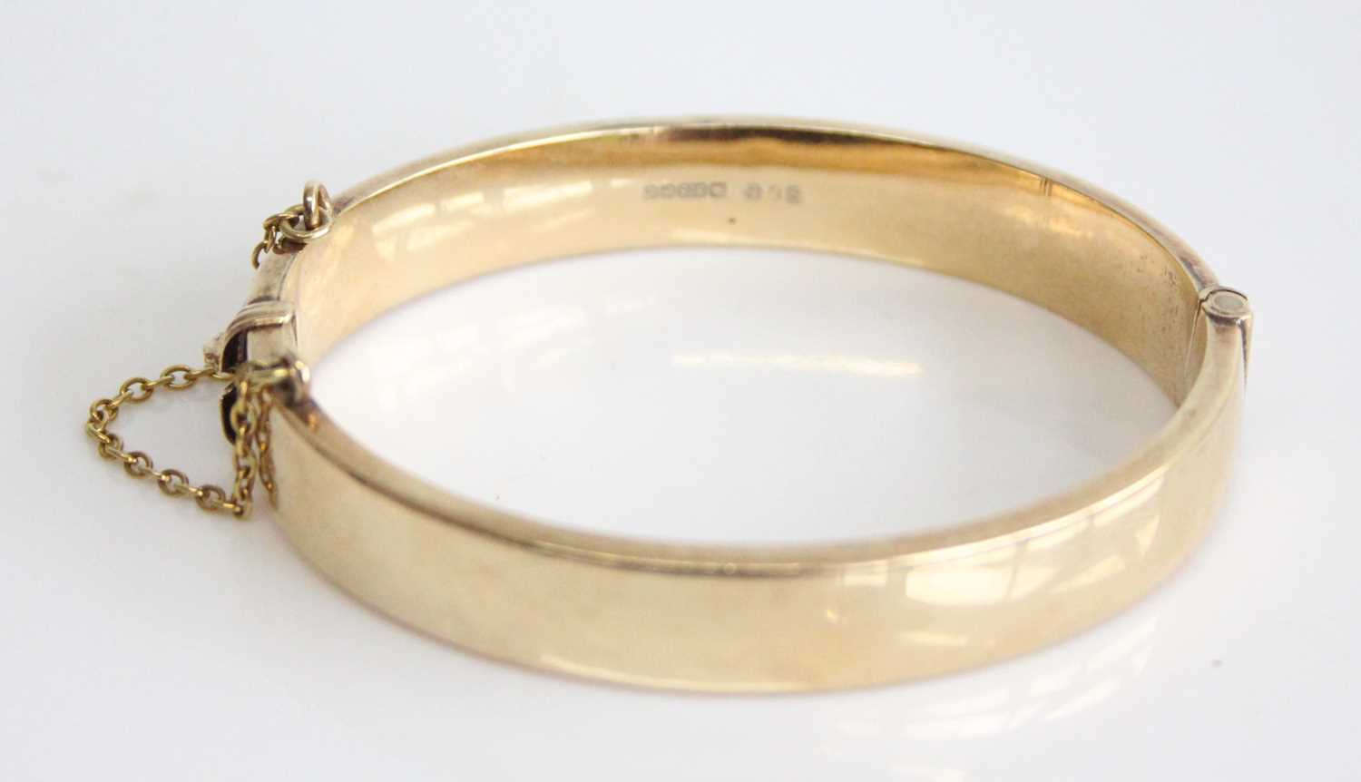 A 9ct yellow gold oval hinged hollow bangle, half engraved with scrollwork detail, with a box - Image 3 of 6