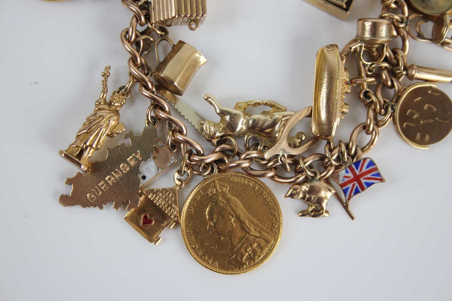 A 9ct gold curblink bracelet containing a collection of charms, principally in 9ct gold and to - Image 4 of 5