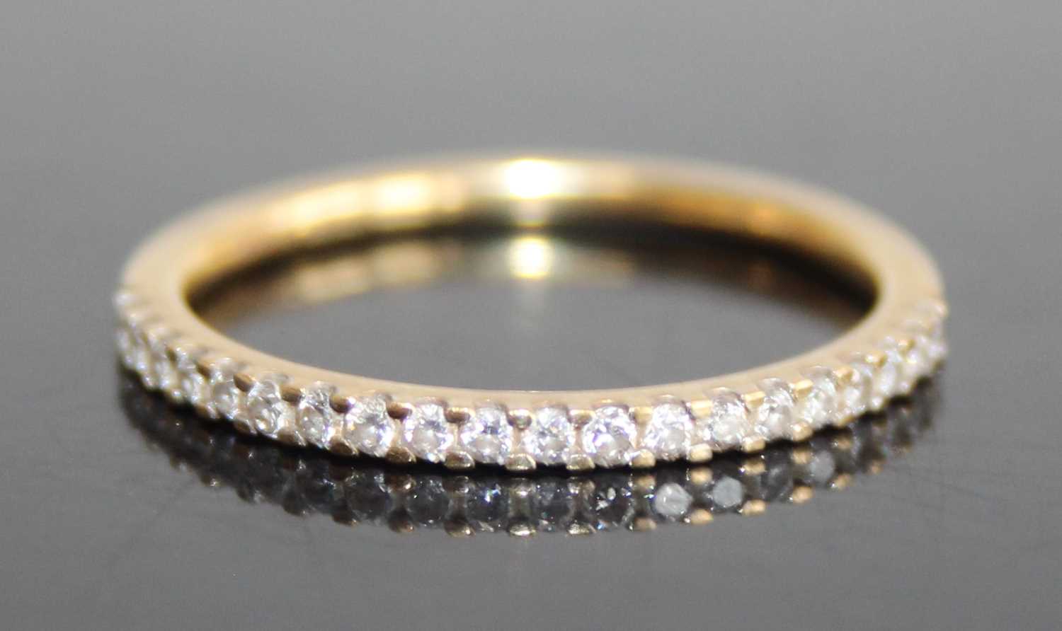 A modern 18ct gold diamond half eternity ring, arranged as twenty small round cuts in a line