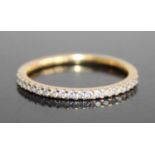 A modern 18ct gold diamond half eternity ring, arranged as twenty small round cuts in a line