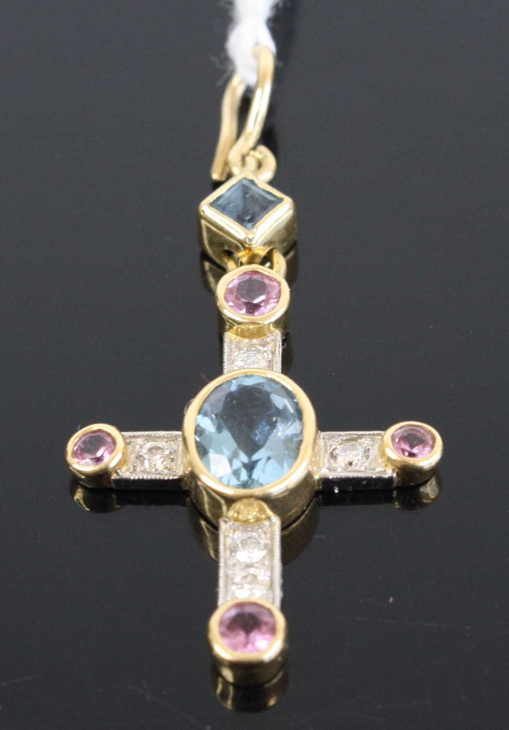 A contemporary yellow & white metal multi-stone set cross pendant, centre set with an oval cut