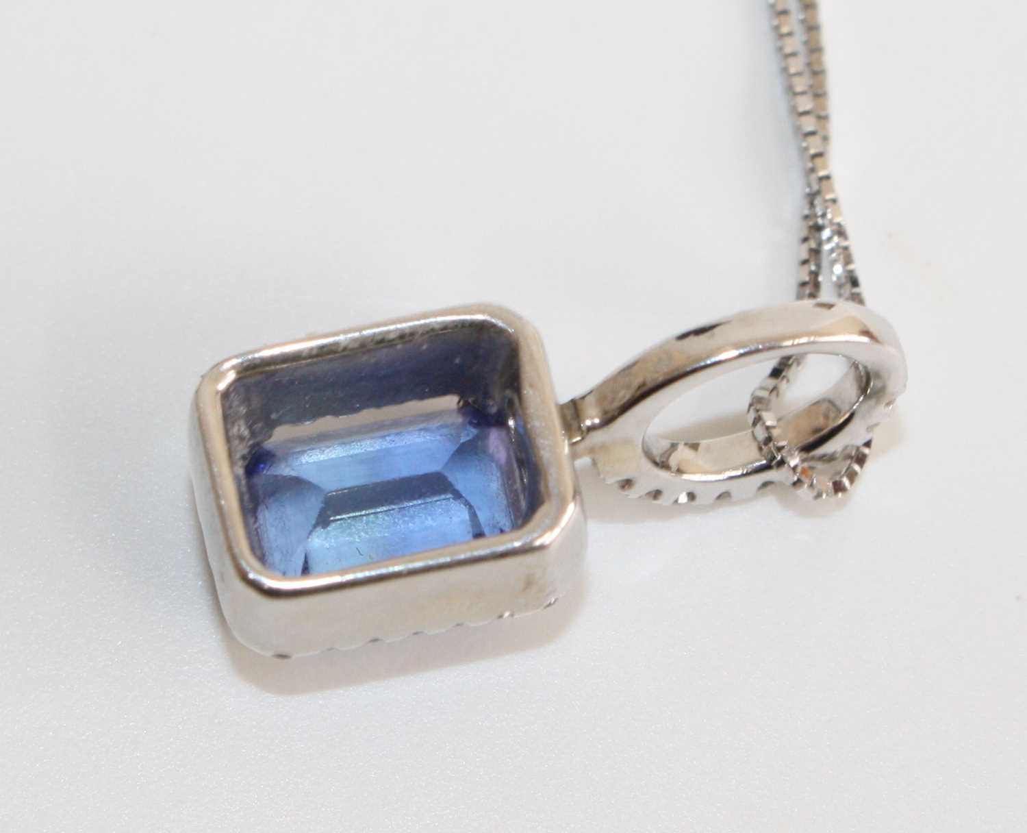 A white metal, tanzanite and diamond rectangular cluster pendant, featuring a centre step-cut - Image 4 of 5