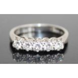 A platinum diamond half hoop ring, arranged as five claw set brilliants in a line setting, total
