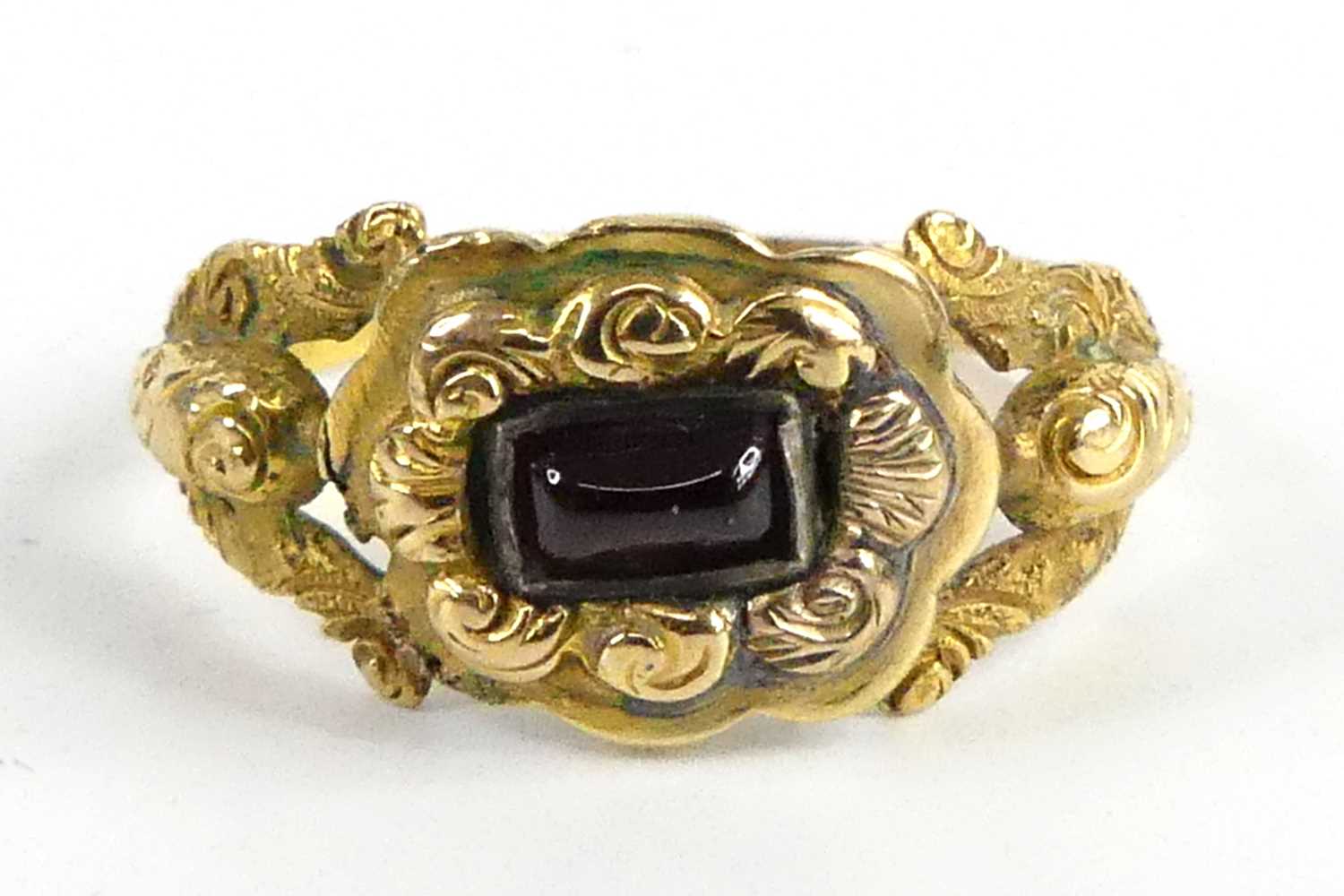 A yellow metal 19th century memorial ring, having a 4.2mm x 2.7mm rectangular garnet cabochon within
