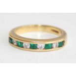 An 18ct gold, emerald and diamond half eternity ring, arranged as five emeralds dispersed with