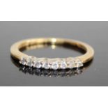 A modern 18ct gold diamond half hoop ring, arranged as eight caw set round brilliants in a line