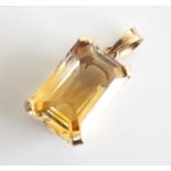 A yellow metal citrine pendant, featuring a rectangular cut citrine in a four-claw setting,