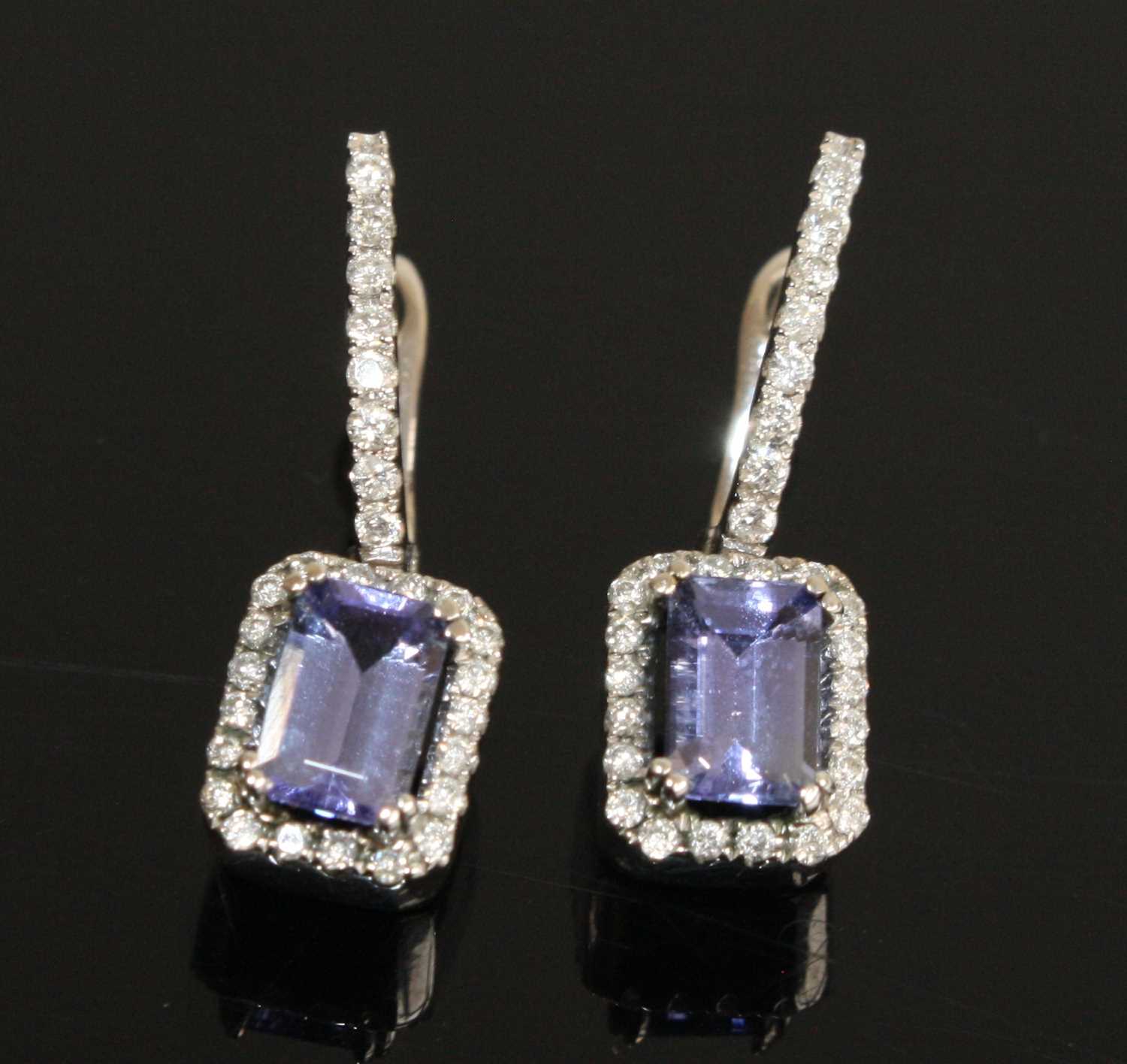 A pair of white metal, tanzanite and diamond drop earrings, each featuring a rectangular cut