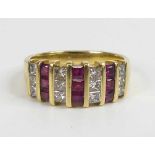 A yellow metal, ruby and diamond three-row half eternity ring, featuring three vertical sections