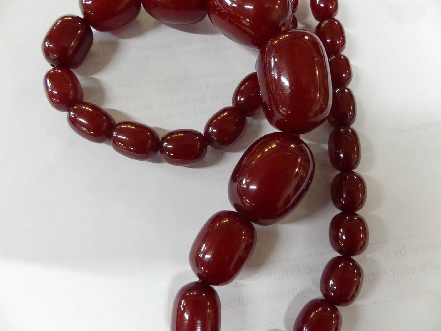 A cherry amber single string necklace, arranged as 40 graduated barrel beads, the largest w.25mm, - Image 9 of 14