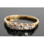 An 18ct gold and platinum diamond half hoop ring, arranged as five claw set graduated round cuts,