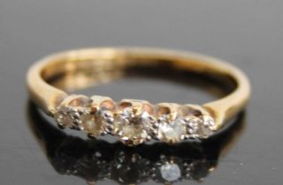 An 18ct gold and platinum diamond half hoop ring, arranged as five claw set graduated round cuts,